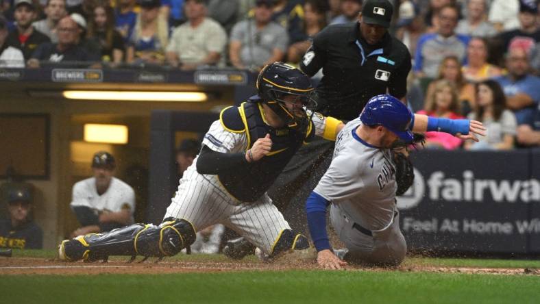 Sep 30, 2023; Milwaukee, Wisconsin, USA; Chicago Cubs left fielder Ian Happ (8) is tagged out by Milwaukee Brewers catcher Victor Caratini (7) in the fourth inning at American Family Field. Mandatory Credit: Michael McLoone-USA TODAY Sports