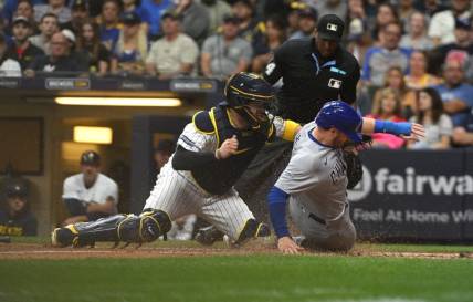 Sep 30, 2023; Milwaukee, Wisconsin, USA; Chicago Cubs left fielder Ian Happ (8) is tagged out by Milwaukee Brewers catcher Victor Caratini (7) in the fourth inning at American Family Field. Mandatory Credit: Michael McLoone-USA TODAY Sports