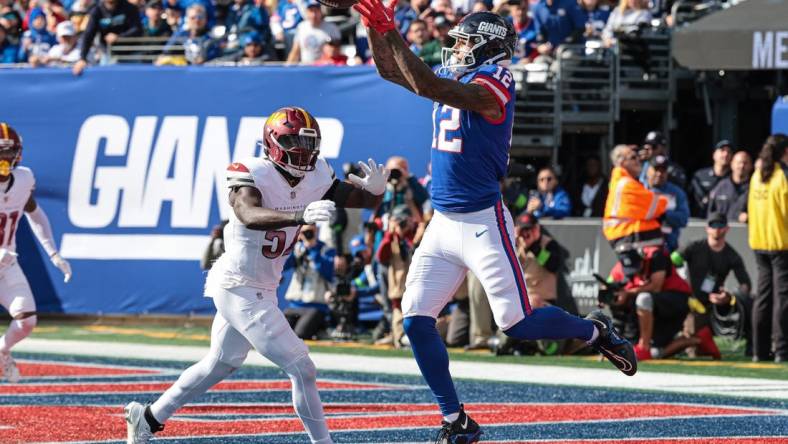 Oct 22, 2023; East Rutherford, New Jersey, USA; New York Giants tight end Darren Waller (12) catches a touchdown pass during the first half in front of Washington Commanders linebacker Cody Barton (57) at MetLife Stadium. Mandatory Credit: Vincent Carchietta-USA TODAY Sports