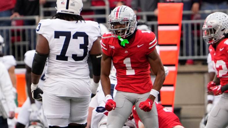 Oct 21, 2023; Columbus, Ohio, USA; Ohio State Buckeyes cornerback Davison Igbinosun (1) celebrates in front of Penn State Nittany Lions offensive lineman Caedan Wallace (73) during the NCAA football game at Ohio Stadium.