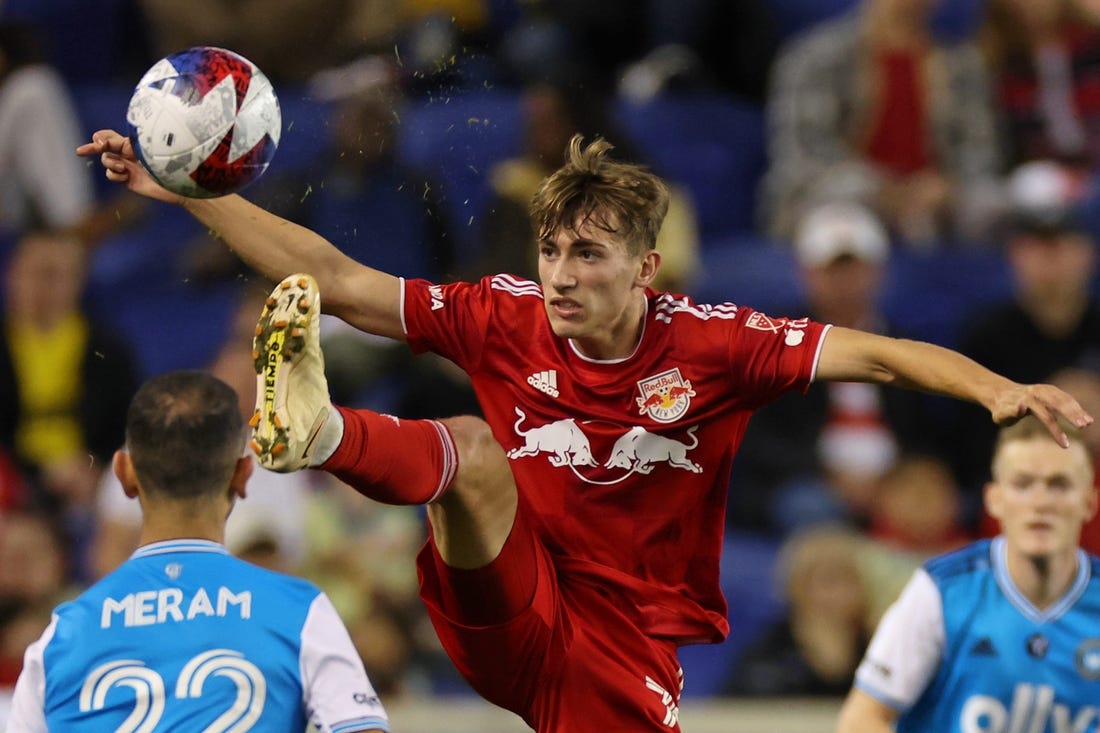 Oct 25, 2023; Harrison, NJ, USA; New York Red Bulls midfielder Daniel Edelman (75) kicks the ball against Charlotte FC forward Justin Meram (22) during the second half in the Eastern Conference Wild Card match of the 2023 MLS Cup Playoffs at Red Bull Arena. Mandatory Credit: Vincent Carchietta-USA TODAY Sports