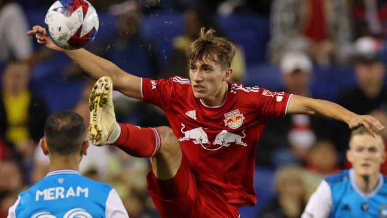 Oct 25, 2023; Harrison, NJ, USA; New York Red Bulls midfielder Daniel Edelman (75) kicks the ball against Charlotte FC forward Justin Meram (22) during the second half in the Eastern Conference Wild Card match of the 2023 MLS Cup Playoffs at Red Bull Arena. Mandatory Credit: Vincent Carchietta-USA TODAY Sports