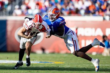 Florida Gators defensive end Princely Umanmielen (1) tackles Georgia Bulldogs quarterback Carson Beck (15) during the first half at Everbank Stadium in Jacksonville, FL on Saturday, October 28, 2023. [Matt Pendleton/Gainesville Sun]