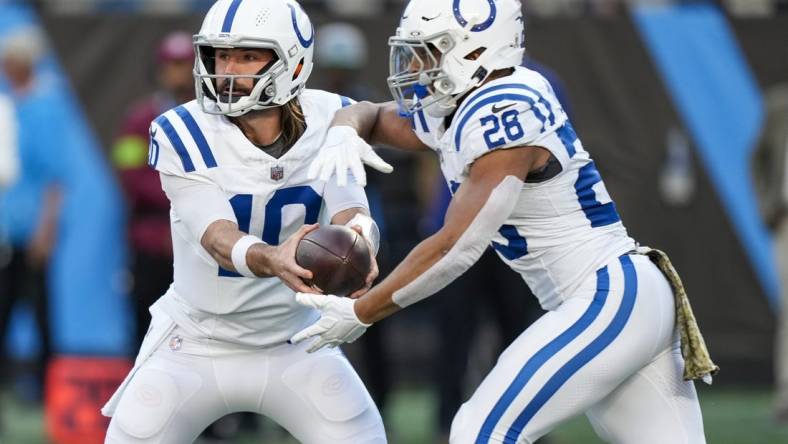 Nov 5, 2023; Charlotte, North Carolina, USA; Indianapolis Colts quarterback Gardner Minshew (10) hands off to running back Jonathan Taylor (28) during the first quarter against the Carolina Panthers at Bank of America Stadium. Mandatory Credit: Jim Dedmon-USA TODAY Sports