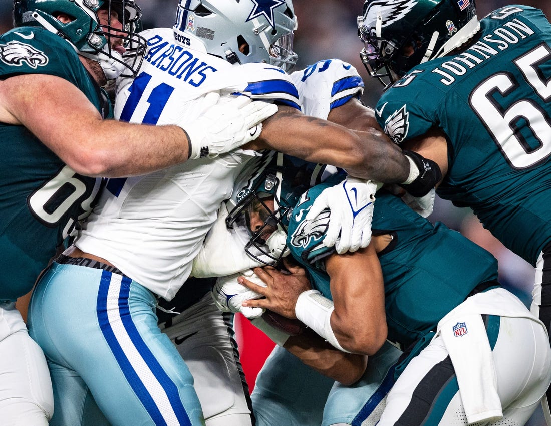 Philadelphia Eagles quarterback Jalen Hurts (1) is tackled by Dallas Cowboys linebacker Micah Parsons (11) during the first quarter at Lincoln Financial Field. Mandatory Credit: Bill Streicher-USA TODAY Sports