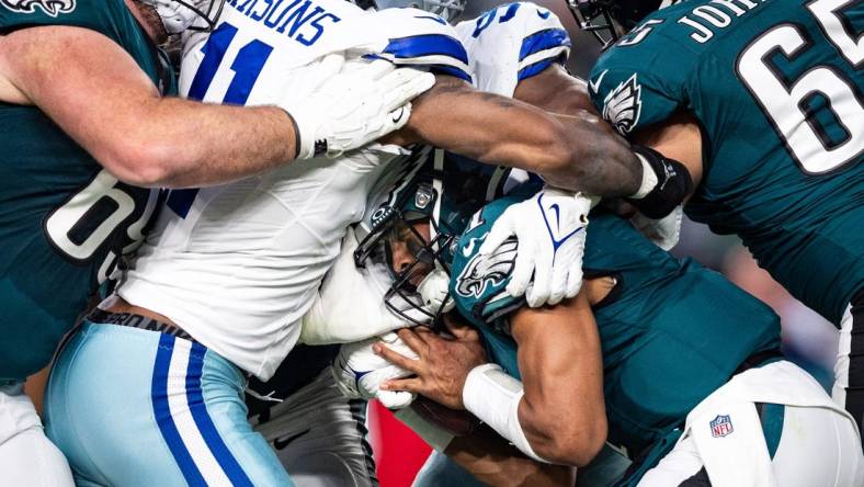 Philadelphia Eagles quarterback Jalen Hurts (1) is tackled by Dallas Cowboys linebacker Micah Parsons (11) during the first quarter at Lincoln Financial Field. Mandatory Credit: Bill Streicher-USA TODAY Sports