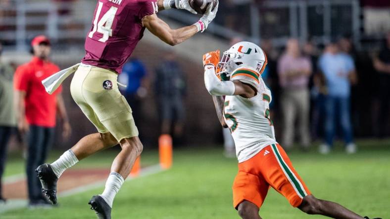 Florida State Seminoles wide receiver Johnny Wilson (14) catches a pass from Florida State Seminoles quarterback Jordan Travis (13). The Florida State Seminoles defeated the Miami Hurricanes 27-20 on Saturday, Nov. 11, 2023.