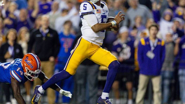 Nov 11, 2023; Baton Rouge, Louisiana, USA;  LSU Tigers quarterback Jayden Daniels (5) rushes for a touchdown against Florida Gators safety Jordan Castell (14) during the first half at Tiger Stadium. Mandatory Credit: Stephen Lew-USA TODAY Sports