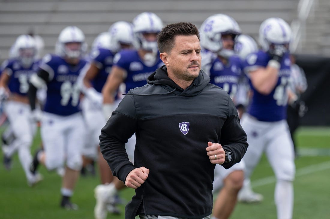 Holy Cross head coach Bob Chesney runs onto the field with the team for their homecoming game versus Colgate University on Saturday September 23, 2023 at Fitton Field in Worcester.