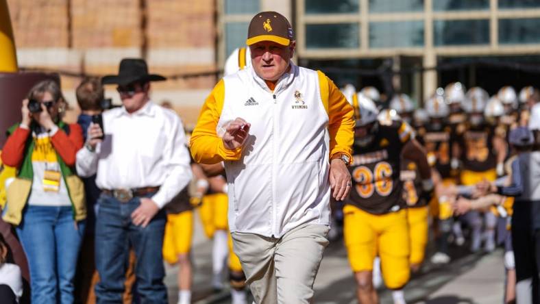 Nov 18, 2023; Laramie, Wyoming, USA; Wyoming Cowboys head coach Craig Bohl leads his team onto the field before the game against the Hawaii Rainbow Warriors at Jonah Field at War Memorial Stadium. Mandatory Credit: Troy Babbitt-USA TODAY Sports