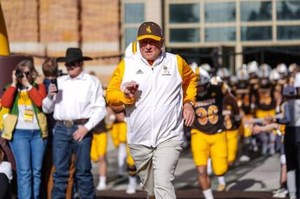 Nov 18, 2023; Laramie, Wyoming, USA; Wyoming Cowboys head coach Craig Bohl leads his team onto the field before the game against the Hawaii Rainbow Warriors at Jonah Field at War Memorial Stadium. Mandatory Credit: Troy Babbitt-USA TODAY Sports