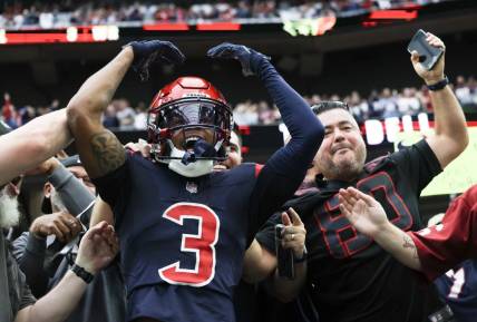 Nov 19, 2023; Houston, Texas, USA;  Houston Texans wide receiver Tank Dell (3) jumps in the stands and celebrates his touchdown against the Arizona Cardinals in the second quarter at NRG Stadium. Mandatory Credit: Thomas Shea-USA TODAY Sports