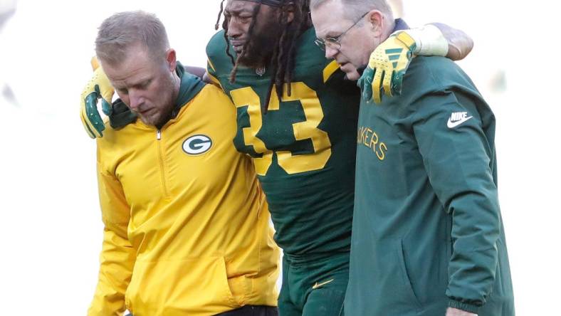 Green Bay Packers running back Aaron Jones (33) is helped off the field after getting injured in the second quarter againsst the Los Angeles Chargers during their football game Sunday, November 19, 2023, at Lambeau Field in Green Bay, Wis.