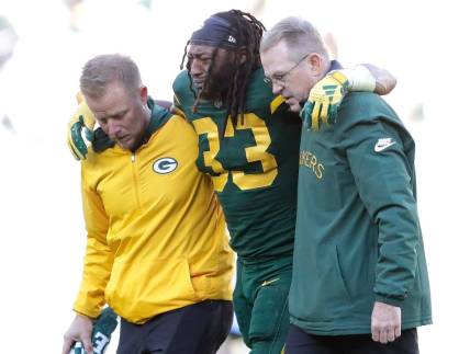 Green Bay Packers running back Aaron Jones (33) is helped off the field after getting injured in the second quarter againsst the Los Angeles Chargers during their football game Sunday, November 19, 2023, at Lambeau Field in Green Bay, Wis.
