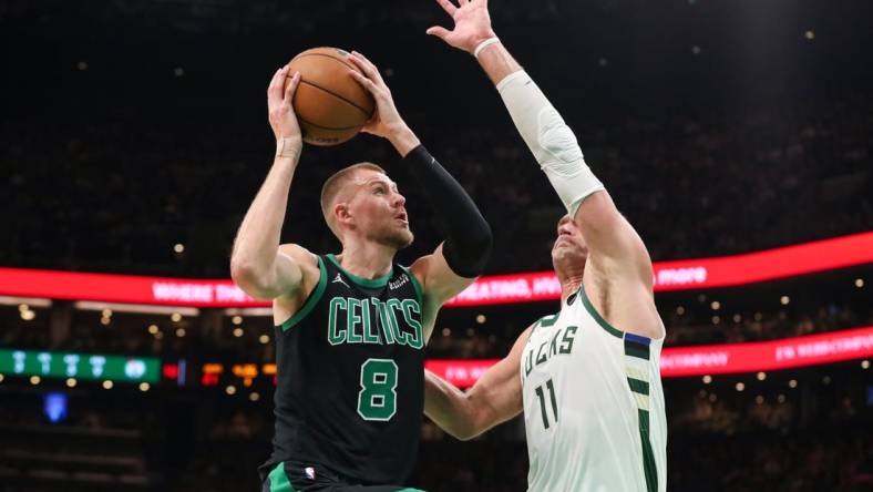 Nov 22, 2023; Boston, Massachusetts, USA; Boston Celtics center Kristaps Porzingis (8) drives to the basket defended by Milwaukee Bucks center Brook Lopez (11) during the first half at TD Garden. Mandatory Credit: Paul Rutherford-USA TODAY Sports