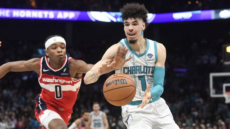 Nov 22, 2023; Charlotte, North Carolina, USA; Charlotte Hornets guard LaMelo Ball (1) catches a pass as Washington Wizards guard Bilal Coulibaly (0) attempts to steal during the second half at the Spectrum Center. Mandatory Credit: Sam Sharpe-USA TODAY Sports