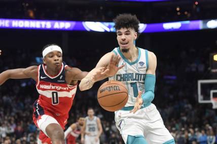 Nov 22, 2023; Charlotte, North Carolina, USA; Charlotte Hornets guard LaMelo Ball (1) catches a pass as Washington Wizards guard Bilal Coulibaly (0) attempts to steal during the second half at the Spectrum Center. Mandatory Credit: Sam Sharpe-USA TODAY Sports