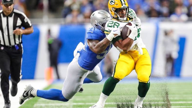 Detroit Lions linebacker Derrick Barnes tackles Green Bay Packers running back A.J. Dillon during the first half at Ford Field in Detroit on Thursday, Nov. 23, 2023.