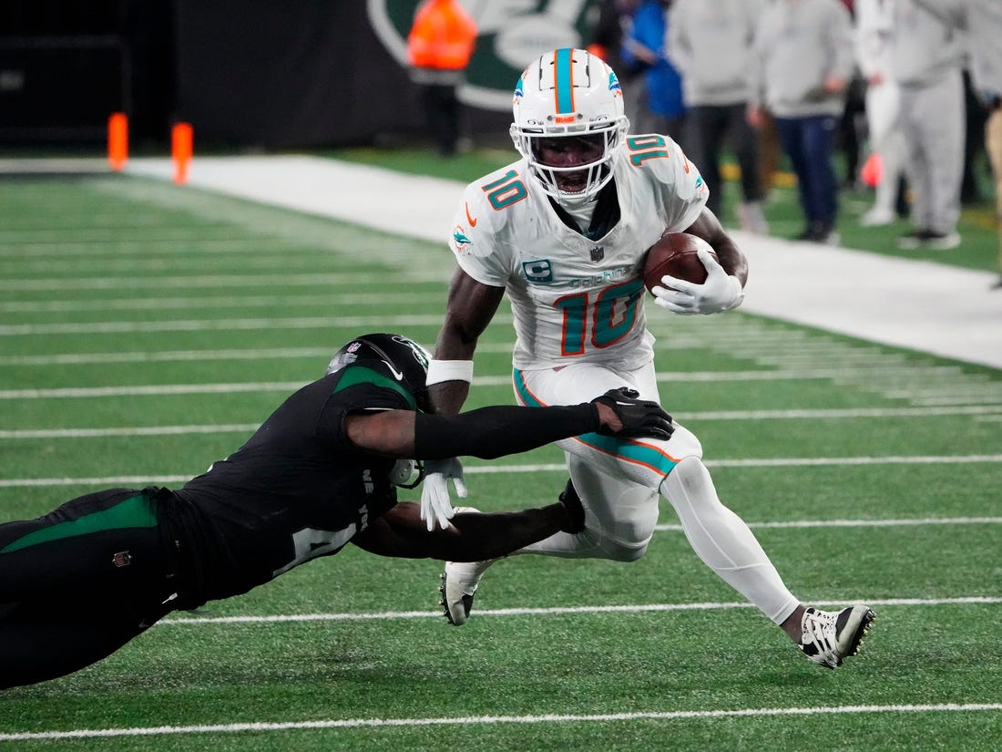 Nov 24, 2023; East Rutherford, New Jersey, USA; Miami Dolphins wide receiver Tyreek Hill (10) is tackled by New York Jets cornerback D.J. Reed (4) in the second half at MetLife Stadium. Mandatory Credit: Robert Deutsch-USA TODAY Sports