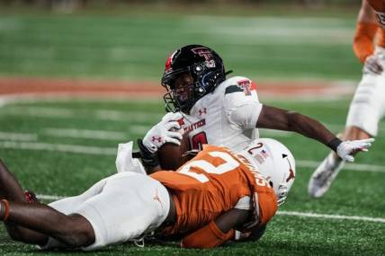 Texas Longhorns defensive back Derek Williams Jr. (2) takes down Texas Tech wide receiver Drae McCray (10) during the game against Texas Tech at Darrell K Royal Texas Memorial Stadium on Friday, Nov. 24, 2023.