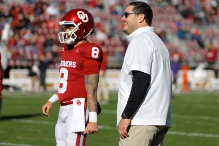 Oklahoma offensive coordinator Jeff Lebby talks with Oklahoma Sooners quarterback Dillon Gabriel (8) before a college football game between the University of Oklahoma Sooners (OU) and the TCU Horned Frogs at Gaylord Family-Oklahoma Memorial Stadium in Norman, Okla., Friday, Nov. 24, 2023. Oklahoma won 69-45.