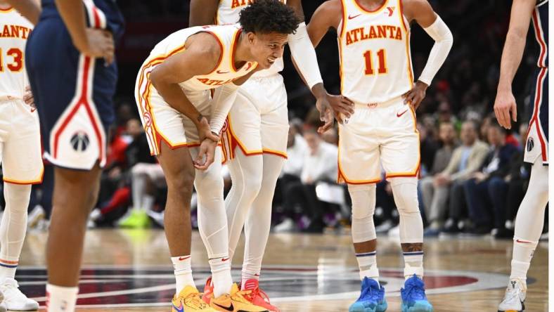 Nov 25, 2023; Washington, District of Columbia, USA; Atlanta Hawks forward Jalen Johnson (1) grabs his arm after suffering an apparent injury against the Washington Wizards during the first half at Capital One Arena. Mandatory Credit: Brad Mills-USA TODAY Sports