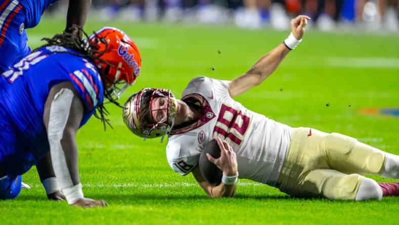 Florida Gators defensive lineman Desmond Watson (21) sacks Florida State Seminoles quarterback Tate Rodemaker (18) during second half action as Florida takes on Florida State at Steve Spurrier Field at Ben Hill Griffin Stadium in Gainesville, FL on Saturday, November 25, 2023. [Alan Youngblood/Gainesville Sun]