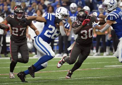Nov 26, 2023; Indianapolis, Indiana, USA; Indianapolis Colts running back Jonathan Taylor (28) runs to get past Tampa Bay Buccaneers cornerback Dee Delaney (30) during the second quarter at Lucas Oil Stadium. Mandatory Credit: Marc Lebryk-USA TODAY Sports