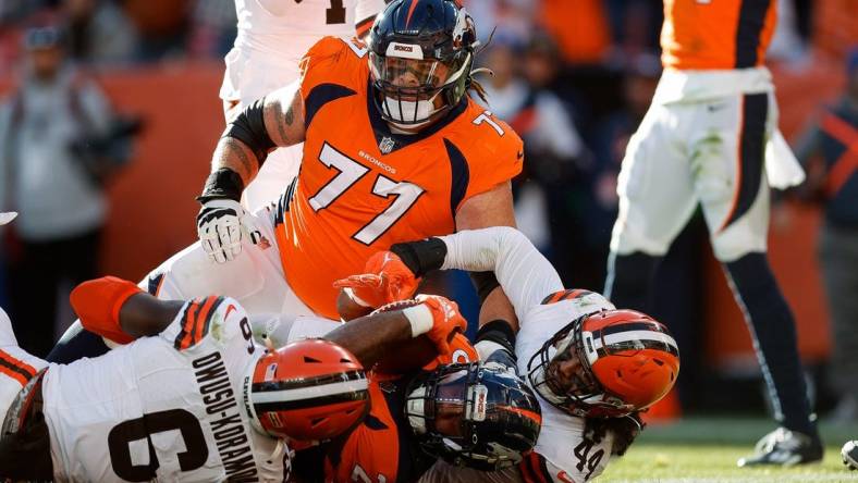 Nov 26, 2023; Denver, Colorado, USA; Denver Broncos running back Samaje Perine (25) scores a touchdown against Cleveland Browns linebacker Jeremiah Owusu-Koramoah (6) and linebacker Sione Takitaki (44) after being pushed into the end zone by guard Quinn Meinerz (77) in the first quarter at Empower Field at Mile High. Mandatory Credit: Isaiah J. Downing-USA TODAY Sports