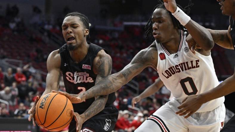 Nov 26, 2023; Louisville, Kentucky, USA;  Louisville Cardinals guard Mike James (0) scrambles for the ball against New Mexico State Aggies guard Jordan Rawls (2) during overtime at KFC Yum! Center. Louisville defeated New Mexico State 90-84. Mandatory Credit: Jamie Rhodes-USA TODAY Sports