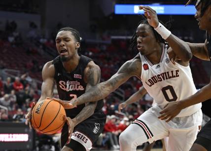 Nov 26, 2023; Louisville, Kentucky, USA;  Louisville Cardinals guard Mike James (0) scrambles for the ball against New Mexico State Aggies guard Jordan Rawls (2) during overtime at KFC Yum! Center. Louisville defeated New Mexico State 90-84. Mandatory Credit: Jamie Rhodes-USA TODAY Sports