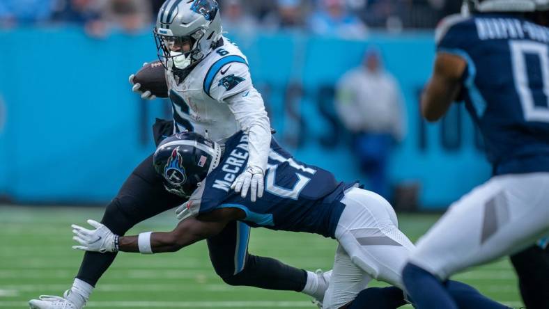 Tennessee Titans cornerback Roger McCreary (21) takes down Carolina Panthers running back Miles Sanders (6) during their game at Nissan Stadium in Nashville, Tenn., Sunday, Nov. 26, 2023.