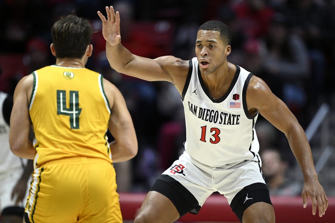 Nov 27, 2023; San Diego, California, USA; San Diego State Aztecs forward Jaedon LeDee (13) defends Point Loma Nazarene Sea Lions guard Coby Barnes (4) during the first half at Viejas Arena. Mandatory Credit: Orlando Ramirez-USA TODAY Sports