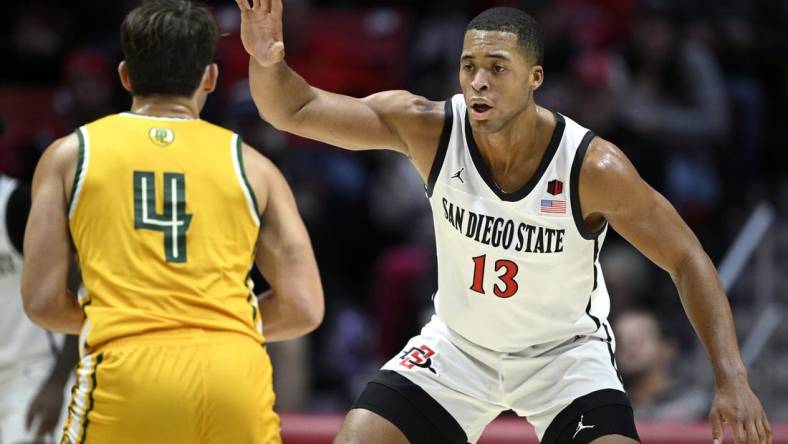 Nov 27, 2023; San Diego, California, USA; San Diego State Aztecs forward Jaedon LeDee (13) defends Point Loma Nazarene Sea Lions guard Coby Barnes (4) during the first half at Viejas Arena. Mandatory Credit: Orlando Ramirez-USA TODAY Sports