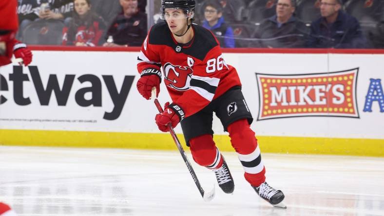 Nov 28, 2023; Newark, New Jersey, USA; New Jersey Devils center Jack Hughes (86) skates with the puck against the New York Islanders during the first period at Prudential Center. Mandatory Credit: Ed Mulholland-USA TODAY Sports