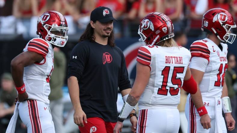 Nov 18, 2023; Tucson, Arizona, USA; Utah Utes quarterback Cameron Rising (middle) on the field during warms ups with quarterback Bryson Barnes (16), quarterback Nate Johnson (13) and quarterback Luke Bottari (15) at Arizona Stadium. Mandatory Credit: Zachary BonDurant-USA TODAY Sports