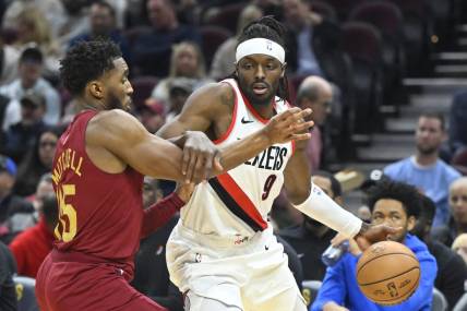 Nov 30, 2023; Cleveland, Ohio, USA; Portland Trail Blazers forward Jerami Grant (9) drives against Cleveland Cavaliers guard Donovan Mitchell (45) in the second quarter at Rocket Mortgage FieldHouse. Mandatory Credit: David Richard-USA TODAY Sports