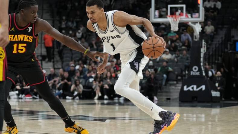 Nov 30, 2023; San Antonio, Texas, USA;  San Antonio Spurs center Victor Wembanyama (1) dribbles against Atlanta Hawks center Clint Capela (15) in the first half at the Frost Bank Center. Mandatory Credit: Daniel Dunn-USA TODAY Sports