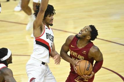 Nov 30, 2023; Cleveland, Ohio, USA; Cleveland Cavaliers guard Donovan Mitchell (45) collides with Portland Trail Blazers guard Shaedon Sharpe (17) in the fourth quarter at Rocket Mortgage FieldHouse. Mandatory Credit: David Richard-USA TODAY Sports