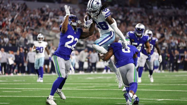 Nov 30, 2023; Arlington, Texas, USA; Dallas Cowboys wide receiver CeeDee Lamb (88) is tackled by Seattle Seahawks cornerback Tre Brown (22) and safety Quandre Diggs (6) during the first half at AT&T Stadium. Mandatory Credit: Tim Heitman-USA TODAY Sports