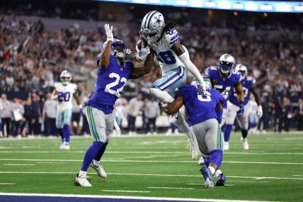 Nov 30, 2023; Arlington, Texas, USA; Dallas Cowboys wide receiver CeeDee Lamb (88) is tackled by Seattle Seahawks cornerback Tre Brown (22) and safety Quandre Diggs (6) during the first half at AT&T Stadium. Mandatory Credit: Tim Heitman-USA TODAY Sports
