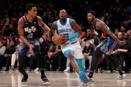 Nov 30, 2023; Brooklyn, New York, USA; Charlotte Hornets guard Terry Rozier (3) drives to the basket against Brooklyn Nets center Nic Claxton (33) and forward Dorian Finney-Smith (28) during the fourth quarter at Barclays Center. Mandatory Credit: Brad Penner-USA TODAY Sports