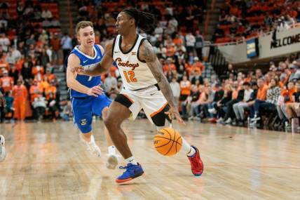 Nov 30, 2023; Stillwater, Oklahoma, USA; Oklahoma State Cowboys guard Javon Small (12) drives to the basket around Creighton Bluejays guard Steven Ashworth (1) during the first half at Gallagher-Iba Arena. Mandatory Credit: William Purnell-USA TODAY Sports