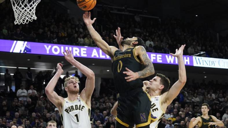 Dec 1, 2023; Evanston, Illinois, USA; Purdue Boilermakers forward Caleb Furst (1) defends Northwestern Wildcats guard Boo Buie (0) during the second half at Welsh-Ryan Arena. Mandatory Credit: David Banks-USA TODAY Sports