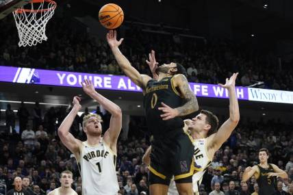 Dec 1, 2023; Evanston, Illinois, USA; Purdue Boilermakers forward Caleb Furst (1) defends Northwestern Wildcats guard Boo Buie (0) during the second half at Welsh-Ryan Arena. Mandatory Credit: David Banks-USA TODAY Sports