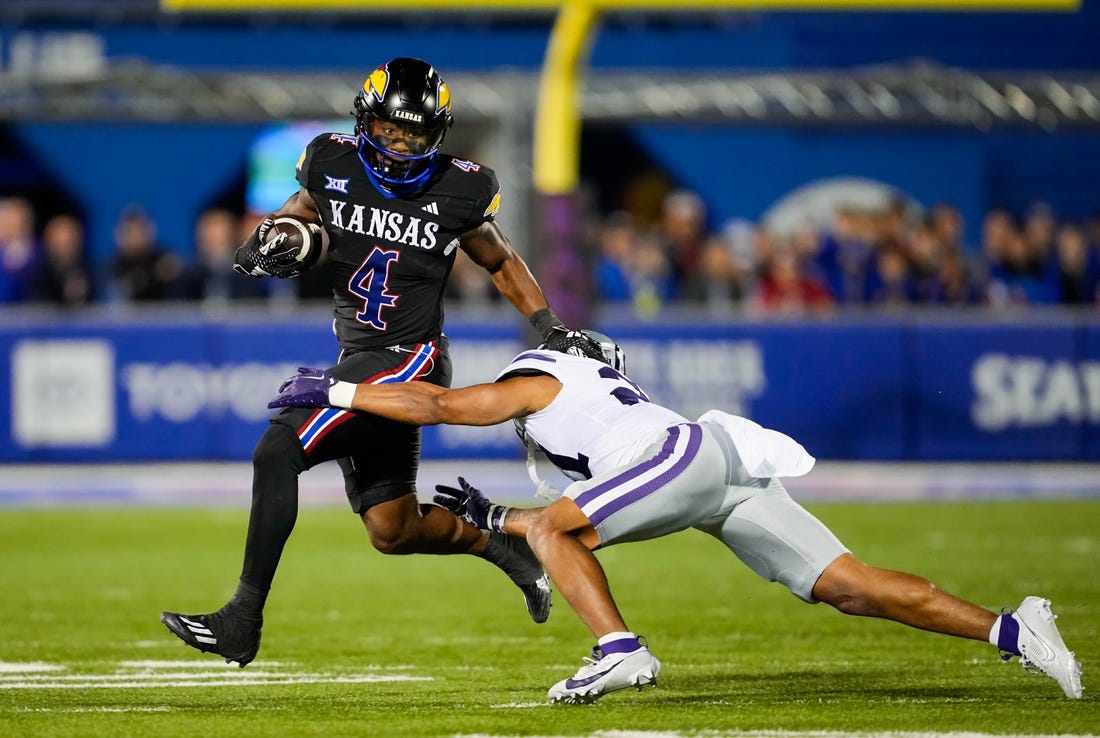 Nov 18, 2023; Lawrence, Kansas, USA; Kansas Jayhawks running back Devin Neal (4) runs the ball against Kansas State Wildcats safety Marques Sigle (21) during the first half at David Booth Kansas Memorial Stadium. Mandatory Credit: Jay Biggerstaff-USA TODAY Sports