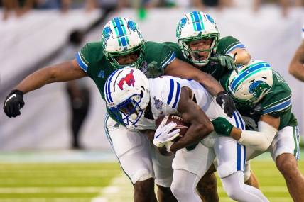 Dec 2, 2023; New Orleans, LA, USA; Southern Methodist Mustangs running back LJ Johnson Jr. (11) is tackled by Tulane Green Wave safety Kam Pedescleaux (8) during the first half at Yulman Stadium. Mandatory Credit: Stephen Lew-USA TODAY Sports