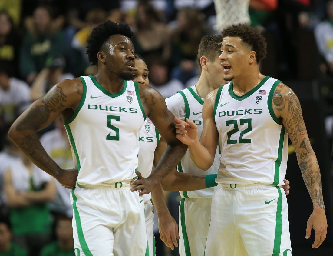 Oregon   s Jermaine Couisnard, left, and Jadrian Tracey meet at mid court during their game against Michigan at Matthew Knight Arena in Eugene Saturday, Dec 2, 2023.