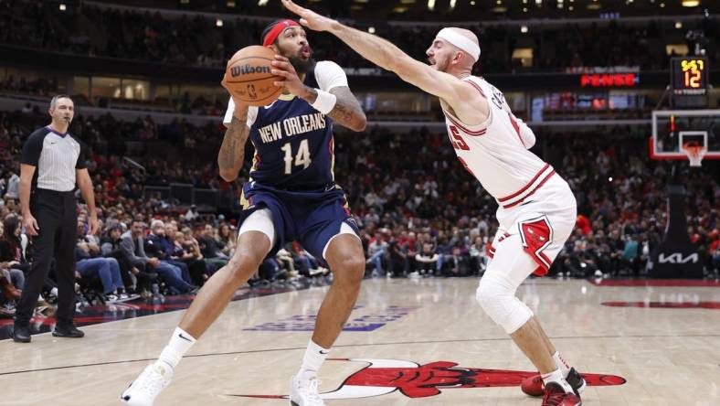 Dec 2, 2023; Chicago, Illinois, USA; New Orleans Pelicans forward Brandon Ingram (14) looks to shoot against Chicago Bulls guard Alex Caruso (6) during the first half at United Center. Mandatory Credit: Kamil Krzaczynski-USA TODAY Sports