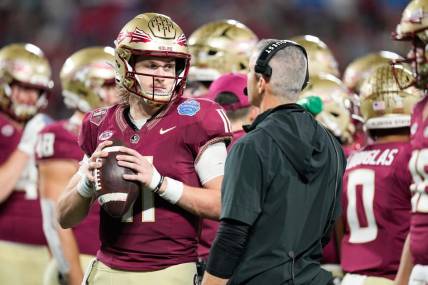 Dec 2, 2023; Charlotte, NC, USA; Florida State Seminoles quarterback Brock Glenn (11) speaks to head coach Mike Norvell on the sidelines during the third quarter against the Louisville Cardinals at Bank of America Stadium. Mandatory Credit: Jim Dedmon-USA TODAY Sports